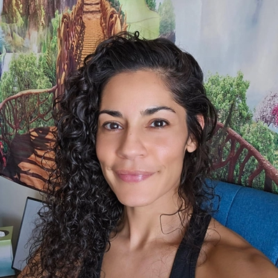 Stephanie Gonzalez smiling, she has curly dark hair.