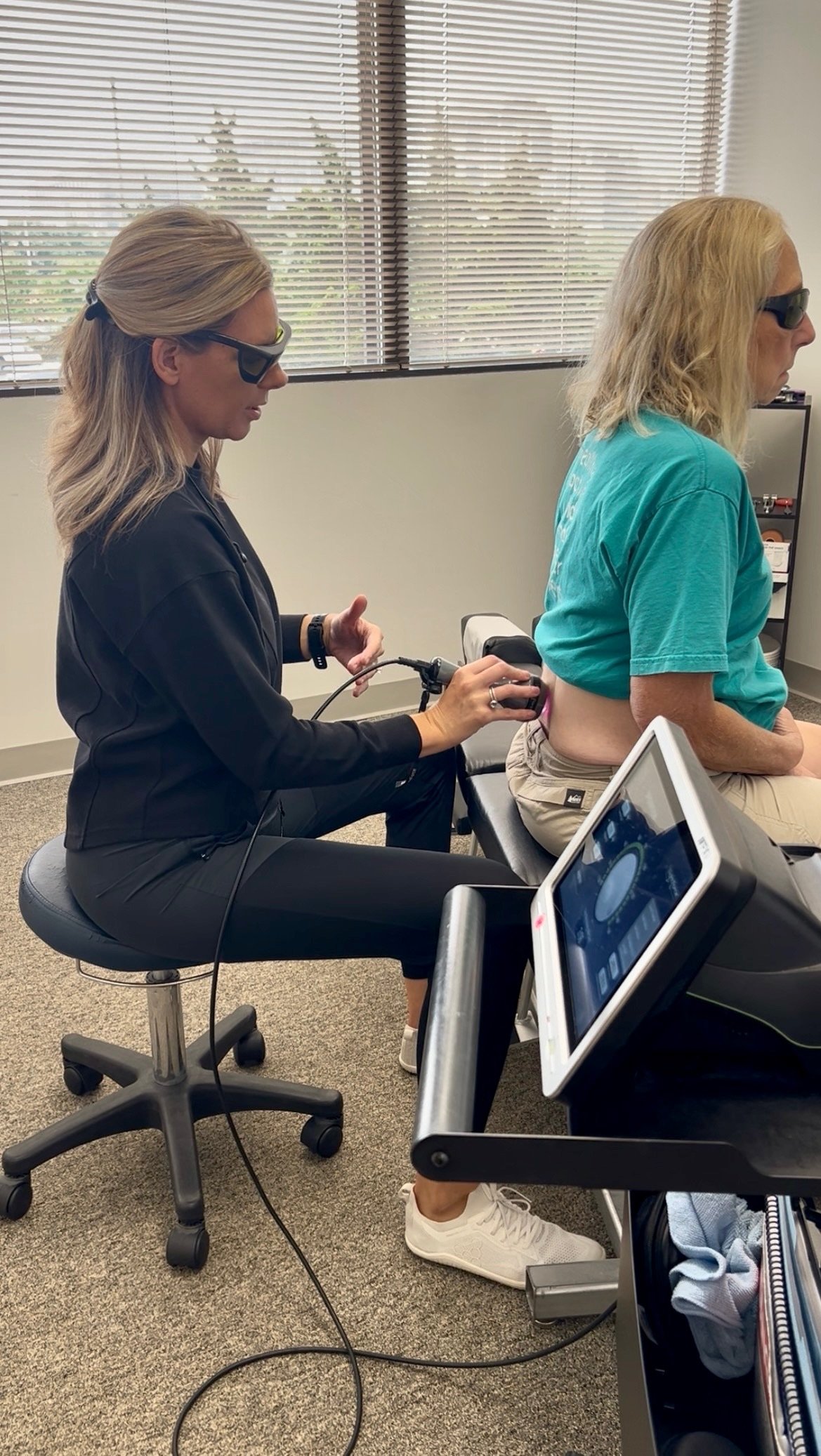 Chiropractor performing cold laser therapy on a patient's low back at True Health Chiropractic in Lombard, IL