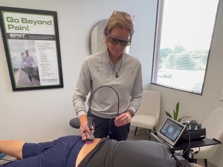 Dr. Amanda Myers performing laser therapy on a patient's low back with the LightForce FXi at True Health in Lombard, IL
