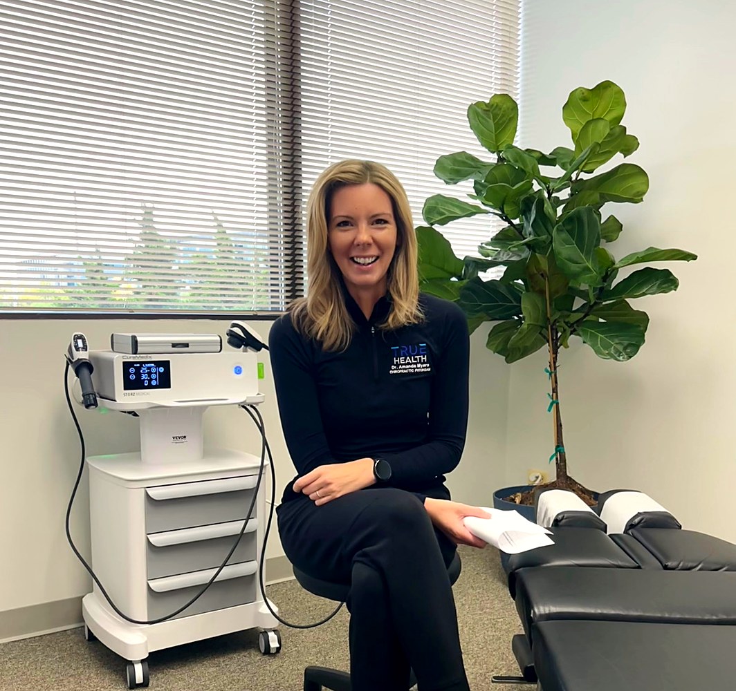 Dr. Amanda Myers with the shockwave therapy unit at True Health Chiropractic in Lombard, IL