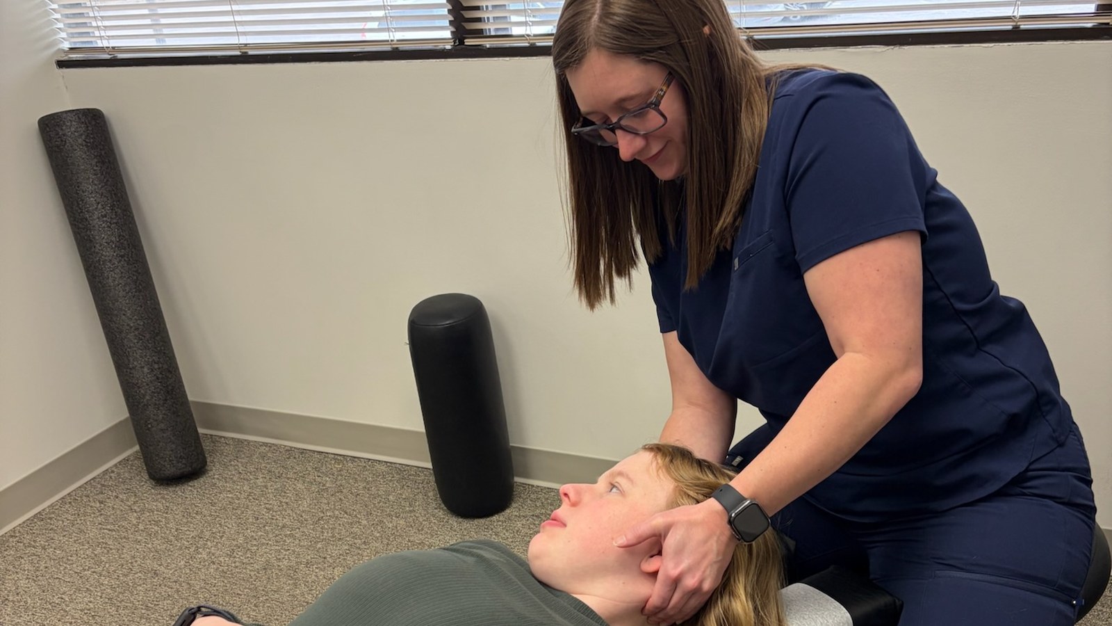 Chiropractor after a car accident performing a neck exam on a patient at True Health in Lombard, IL