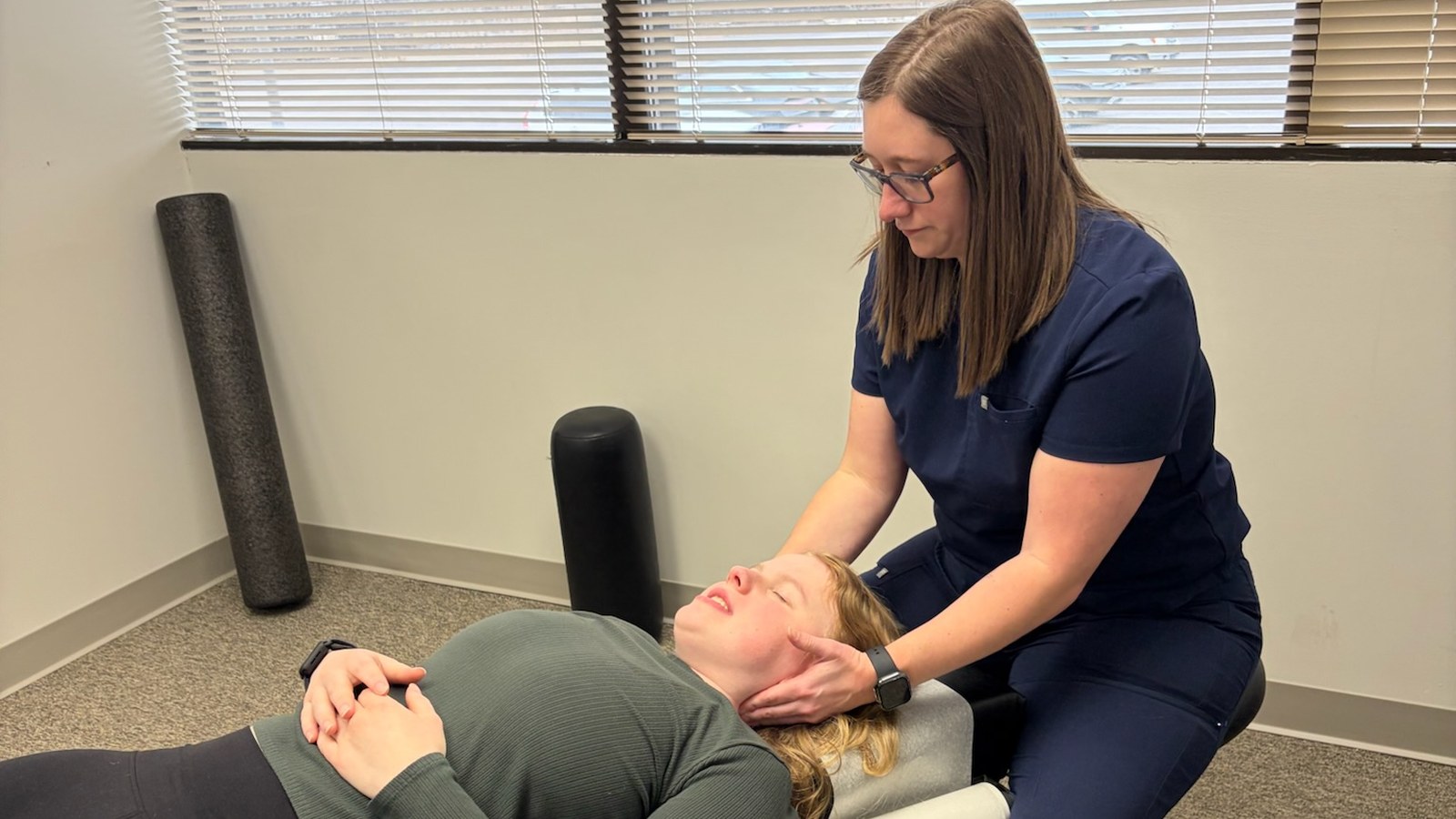 Chiropractor examining a patient's neck for a pinched nerve in neck vs upper back at True Health in Lombard, IL