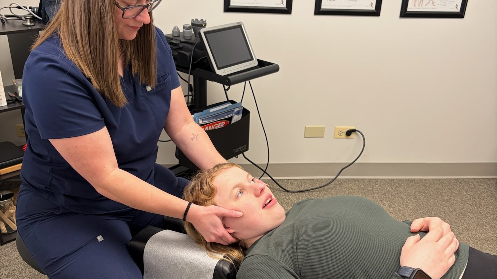 Chiropractor for shoulder pain: Dr. Amanda Myers assessing a patient's neck and shoulder at True Health in Lombard, IL